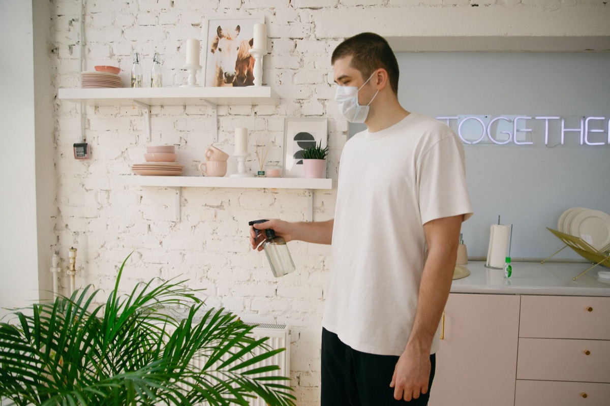 Flacon de spray nettoyant anti-moisissure posé près d'un mur